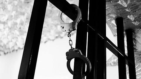 A handcuff hanging on bar.