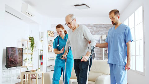 Two health professionals taking care of an elderly patient.