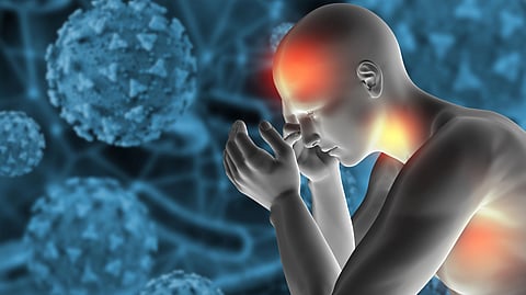 A man holds his head in pain, with a virus graphic shown in front of him.