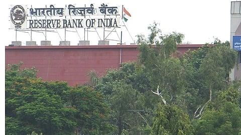 RBI building with red bricks and trees in front.