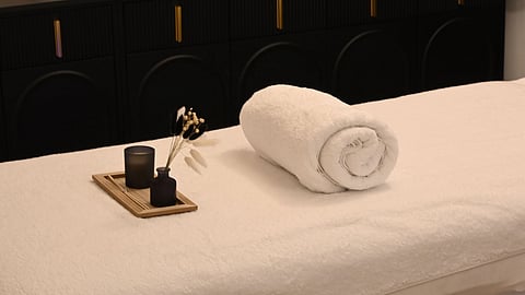 A peaceful spa room with a massage table, candles, and relaxing decor.