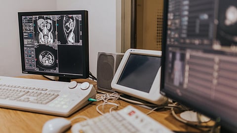 A desk featuring two computer monitors and a keyboard, arranged for a dual-screen workspace setup.