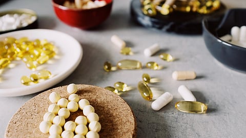 A variety of vitamin supplements displayed on a table, including bottles and capsules.