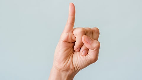 A person displaying a thumbs-up gesture with their thumb and index finger raised.