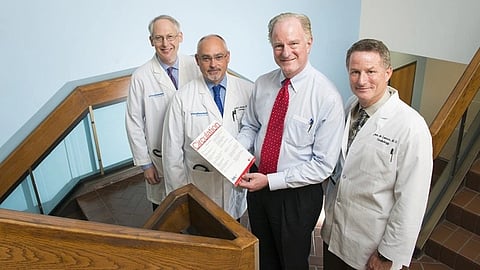 Joseph a. hill and three doctors pose together, with one holding a copy of the Circulation journal.