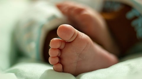 Close-up of a toddler's feet on a bed.