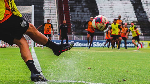 A powerful low-angle shot captures a soccer player striking the ball with speed, force, and precision.