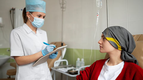 A nurse draws blood from a patient in a clinic.