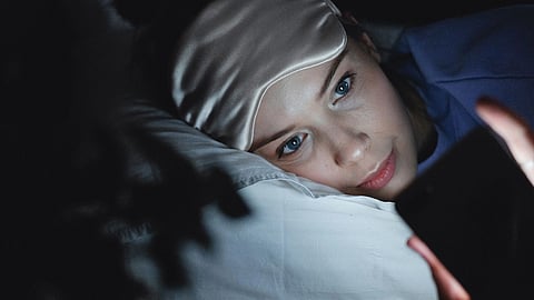 A woman resting in bed on a soft pillow.