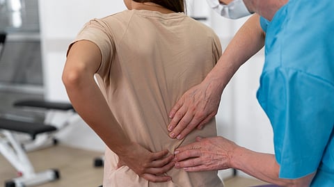 A doctor gives a woman a therapeutic back massage in a clinic.