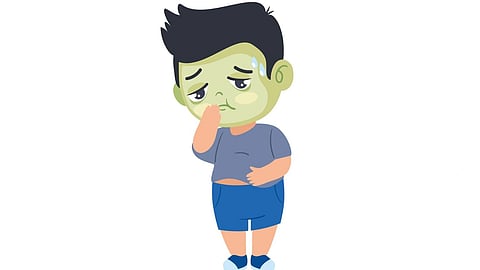 A sick boy holds his stomach and feels like vomiting.