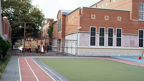 A school running track surrounds a green sports field.