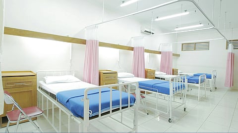 Hospital ward with multiple patient beds arranged inside a healthcare facility.