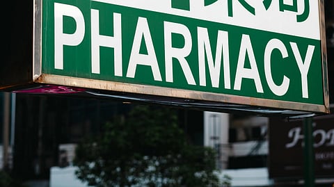 A pharmacy board in green and white.