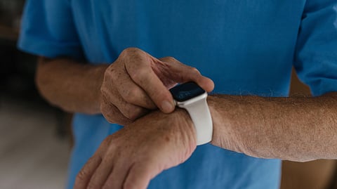 Person tapping an Apple Watch on their wrist.