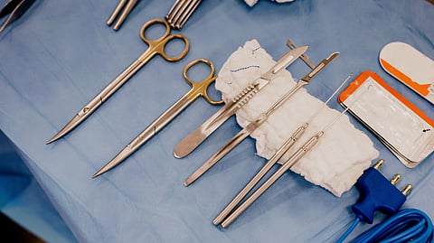 Surgery equipents kept on blue sheet.