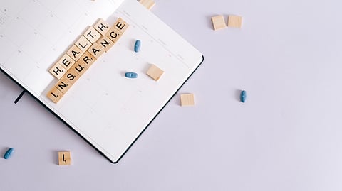 A notebook with the words "Health Insurance."