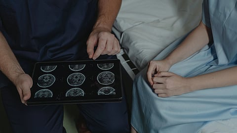 A doctor talks with a patient in a hospital room.