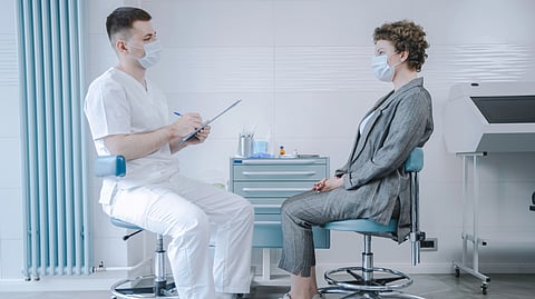 A doctor talks with a patient in a clinic.