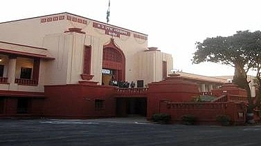 A pink and marron MP court with trees in front.