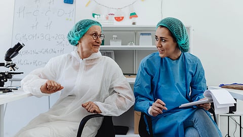 Two researchers discuss notes in a laboratory.