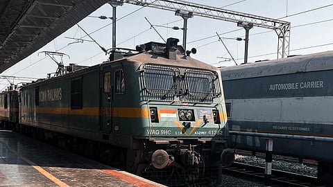 An electric locomotive standing at a railway station platform.