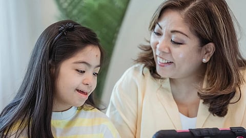 A mother and daughter bonding while using tablet a warm joyful interaction.