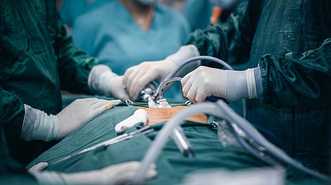Surgeons perform a laparoscopic operation in an operating room.