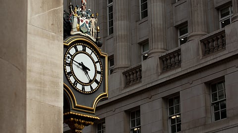 A decorative clock on a stone building.
