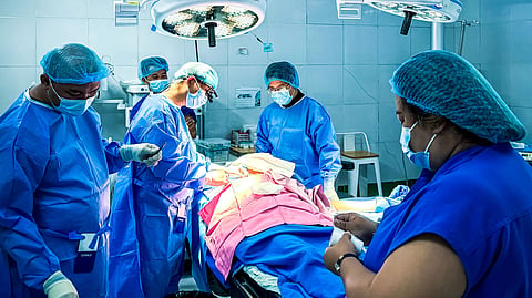 A surgical team performs a procedure in an operating room.
