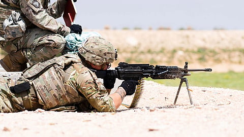 A soldier fires an M249 machine gun during training.
