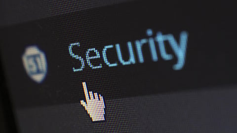 A close-up of a computer screen showing "Security" with a shield icon and a cursor pointing at it.