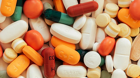 A close-up view of a pile of prescription and over-the-counter medicines.