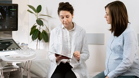 A doctor shows ultrasound results to a pregnant woman during a prenatal checkup.