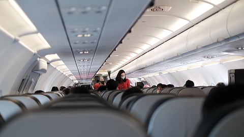 Passengers seated inside a commercial airplane cabin.