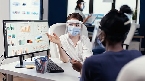 An office worker reviews data on a computer screen.