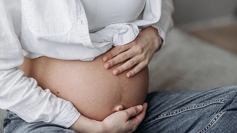 A close-up of a pregnant person's belly.