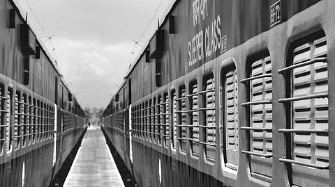 Two trains stand at a railway station platform.