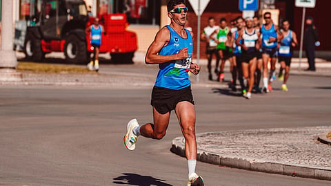 A runner leads a marathon race on a city street.