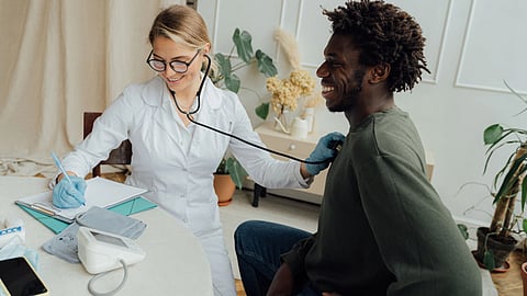 A doctor examines a patient with a stethoscope during a routine check-up.