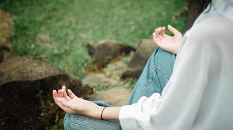 Close-up of a person meditating outdoors.