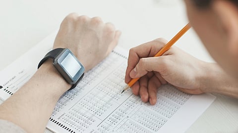 Student filling an OMR answer sheet during a competitive examination.