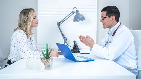 A doctor talks with a patient during a medical consultation.