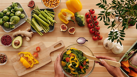 A top view of fresh vegetables, grains, and healthy cooking ingredients.