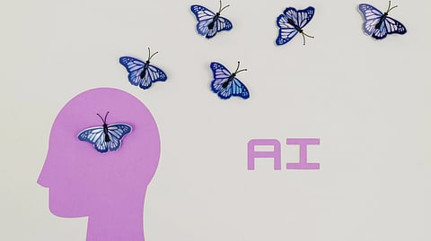 A paper head silhouette with butterflies and the letters “AI,” representing mental health and artificial intelligence.
