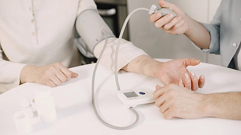 An older woman has her blood pressure checked during a health exam.