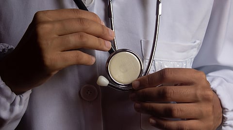 A doctor's hand holding a stethoscope.
