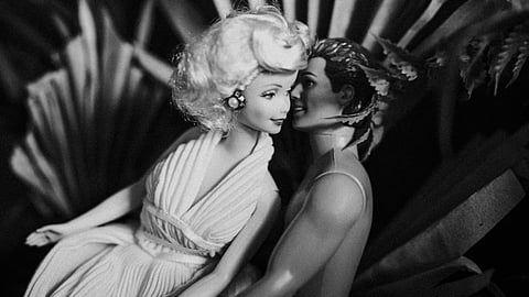 A black-and-white photo of Barbie and Ken posing together.