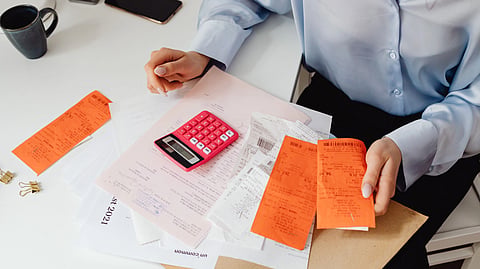 A person organizes receipts and documents at a desk.