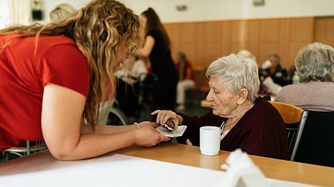 Old woman eating at a table